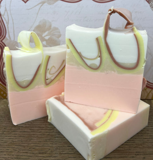 AMROMA THERAPY GOAT MILK & OLIVE OIL SOAP white bar with pink and brown and yellow swirls. Front