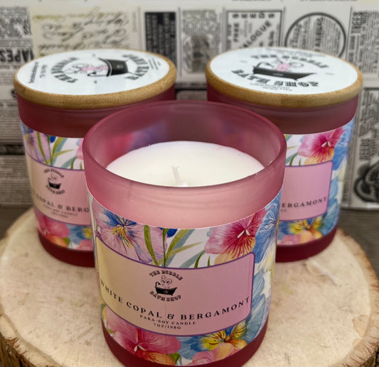 White copal and bergamot para-soy candle from The Bubble Bath Shop, showing a white candle with a minimalist label.